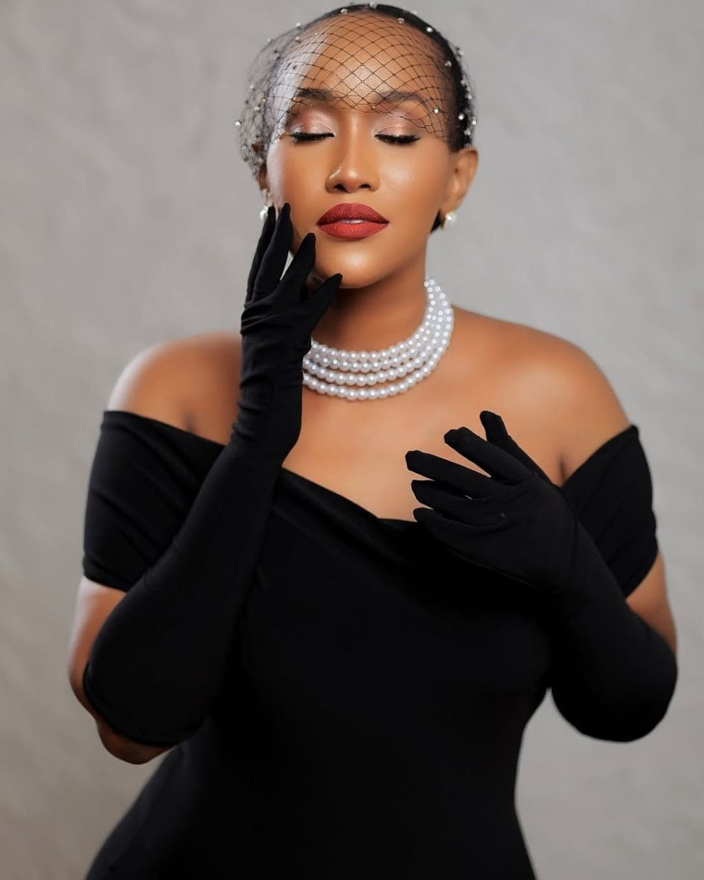 Vintage-inspired glam with birdcage veil and bold red lip